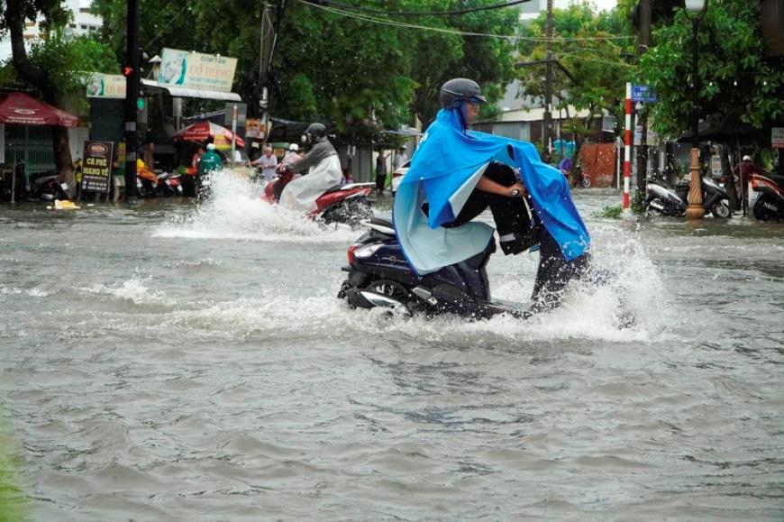 Người dân vất vả di chuyển qua các tuyến đường bị ngập sâu vào sáng ngày 11.7. Ảnh: Nguyên Anh