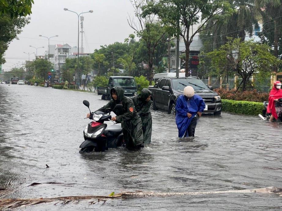 Bộ đội hỗ trợ người dân qua khu vực ngập sâu trên đường Lạc Hồng. Ảnh: Phương Vũ