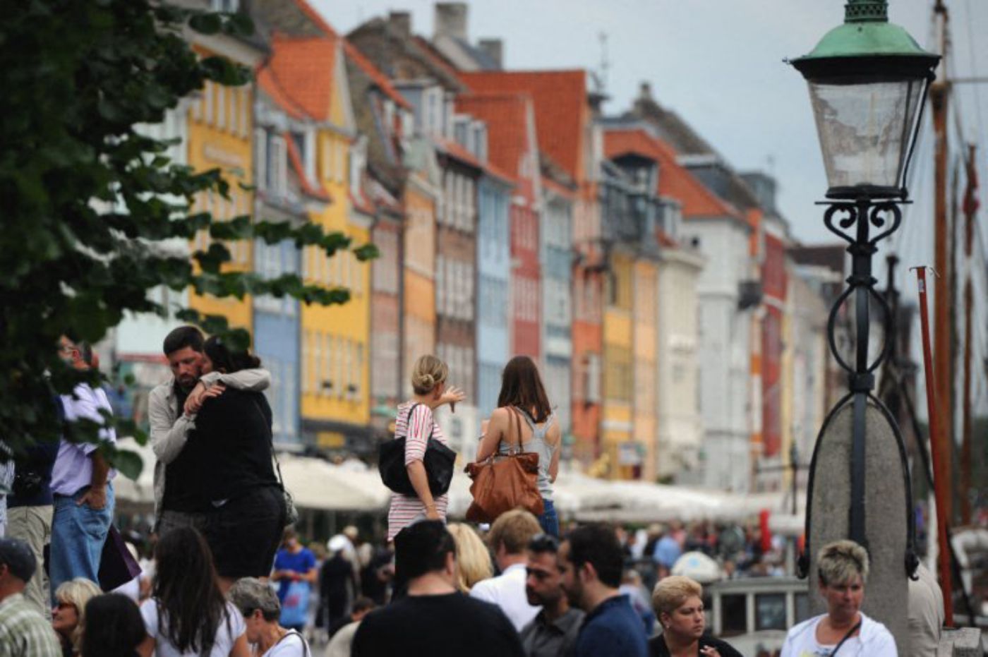 Người đi bộ ở khu phố đầy màu sắc Nyhavn của Copenhagen, Đan Mạch. Ảnh: AFP