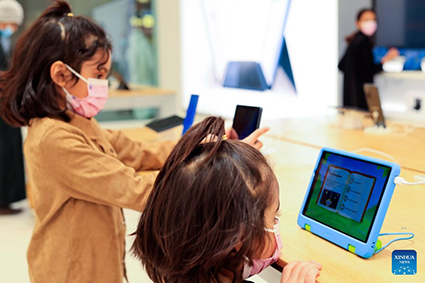 Hai bé gái đang dùng thử sản phẩm công nghệ tại một cửa hàng ở Riyadh, Saudi Arabia, tháng 2 năm 2022. Ảnh: Xinhua