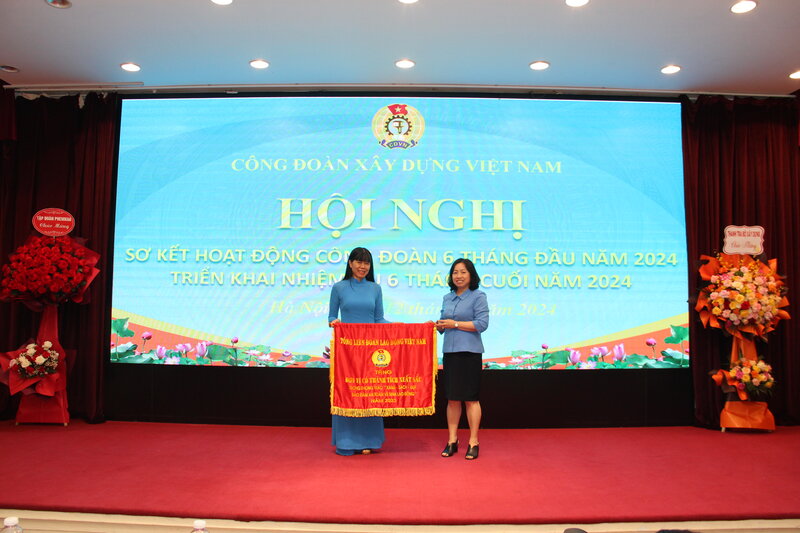Phó Chủ tịch Thường trực Tổng Liên đoàn Lao động Việt Nam Thái Thu Xương (bên phải) trao Cờ Thi đua tới đơn vị. Ảnh: Mạnh Tùng 