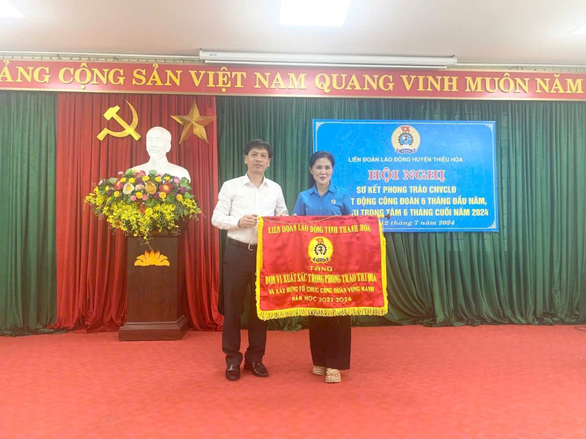 Đại diện lãnh đạo LĐLĐ tỉnh Thanh Hóa trao Cờ thi đua cho đơn vị có thành tích xuất sắc. Ảnh: Thúy Hà