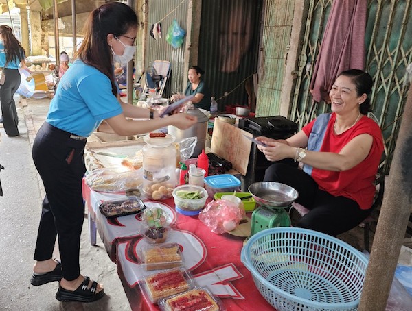 Cán bộ BHXH TP Hà Nội tuyên truyền chính sách BHXH tự nguyện tới người dân. Ảnh: BHXH Hà Nội