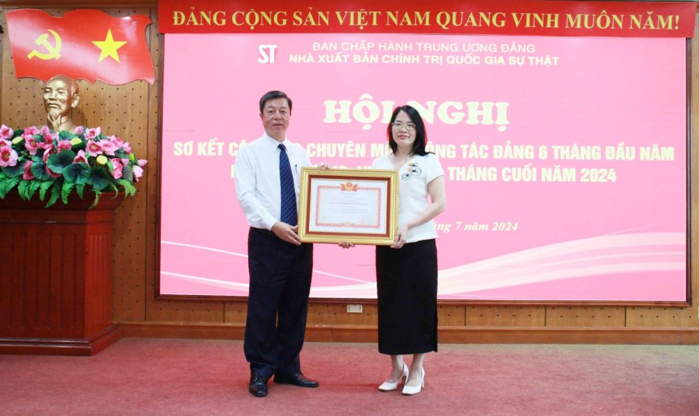 PGS.TS. Vũ Trọng Lâm trao tặng Danh hiệu “Chiến sĩ thi đua toàn quốc” cho bà Nguyễn Hoài Anh, Phó Giám đốc - Phó Tổng Biên tập Nhà xuất bản. Ảnh: T.Vương