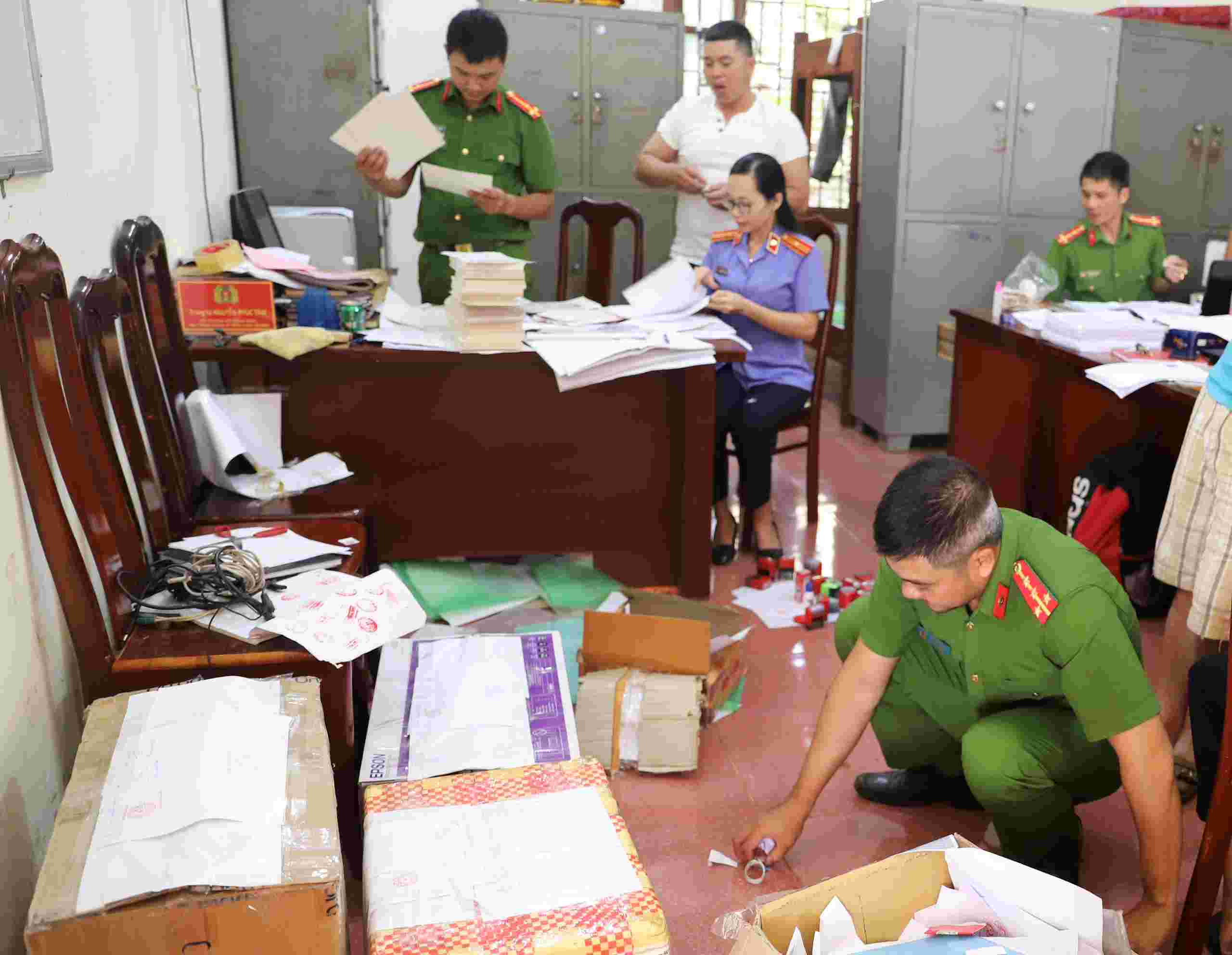 Cơ quan chức năng khám xét một vụ việc làm giả tài liệu của cơ quan, tổ chức. Ảnh: Công an cung cấp