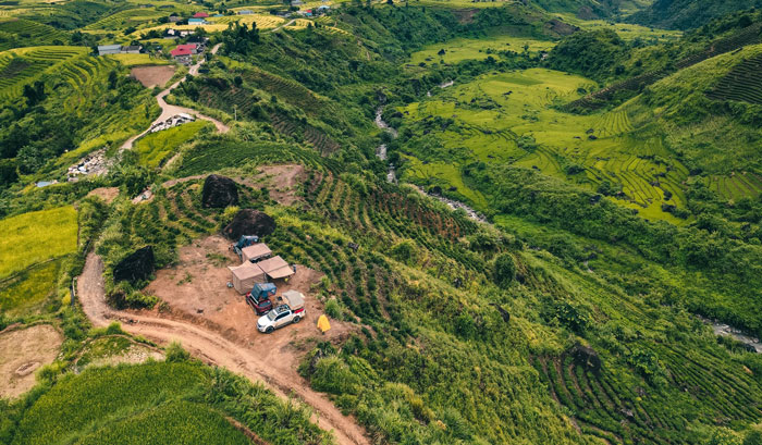 Bên dưới điểm cắm trại là dòng suối trong vắt, phía xa là những thửa ruộng bậc thang, đồi chè và dãy núi hùng vĩ.