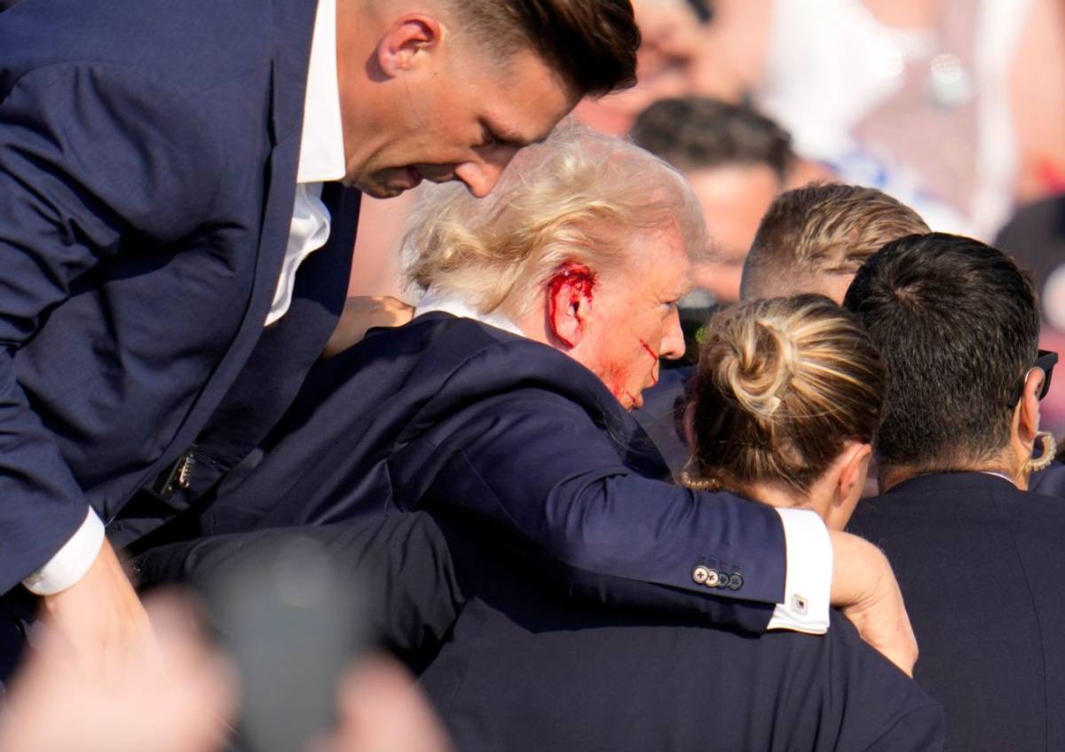 Ông Donald Trump với bên tai chảy máu được Mật vụ Mỹ đưa ra khỏi hiện trường. Ảnh chụp màn hình