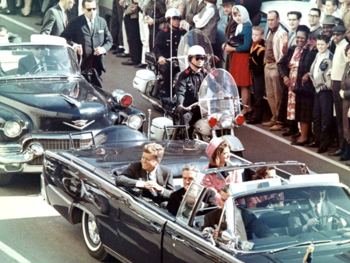 President John F. Kennedy and his wife in an open car before being assassinated. Screenshots