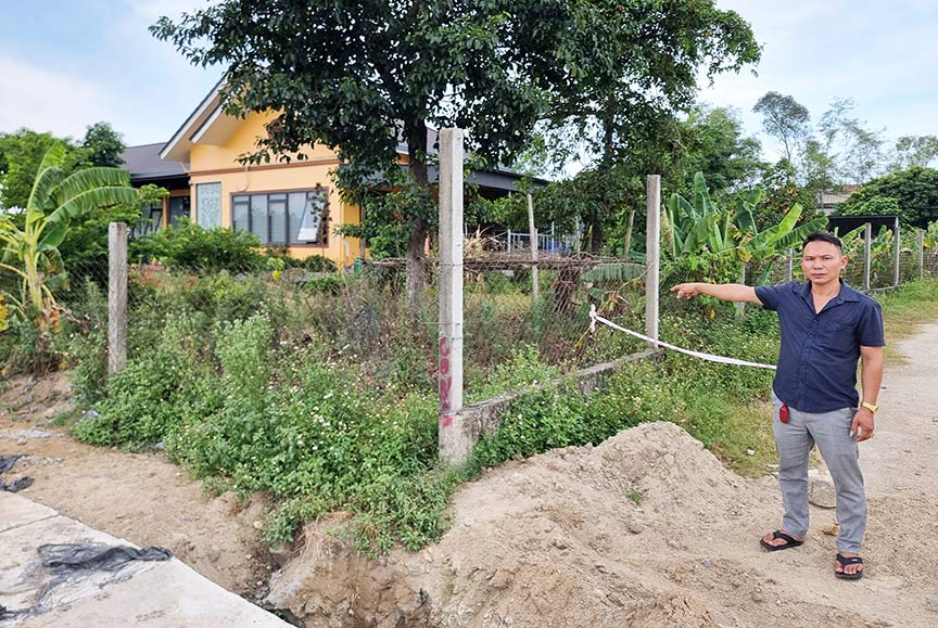 Ông Nguyễn Đình Thái (xã Nghi Phong, huyện Nghi Lộc, Nghệ An) bên mảnh đất đã mua trúng đấu giá nhưng chưa giải phóng mặt bằng.  Ảnh: Quang Đại