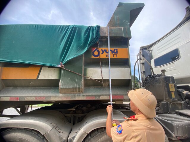 Traffic police check the height of the truck bed. Photo: Minh Nguyen