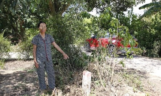Bà Lê Thị Gái và mốc lộ giới hiến đất của gia đình. Ảnh: Công Sáng