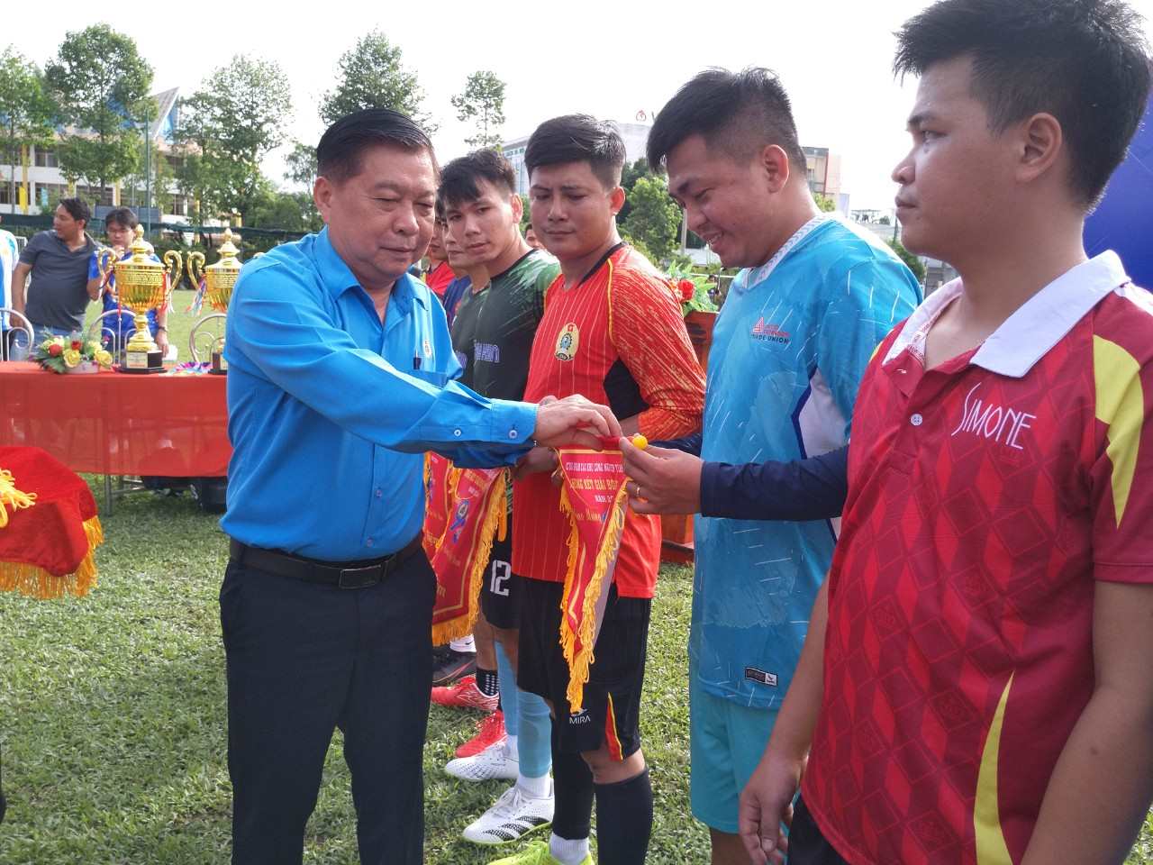 Long a Labor Federation의 회장은 Long Industrial 공원에서 남성 및 여성 노동자의 미니 풋볼 토너먼트의 마지막 라운드에 참여하는 팀에 기념품 깃발을 수여했습니다. 사진 : 경이로움