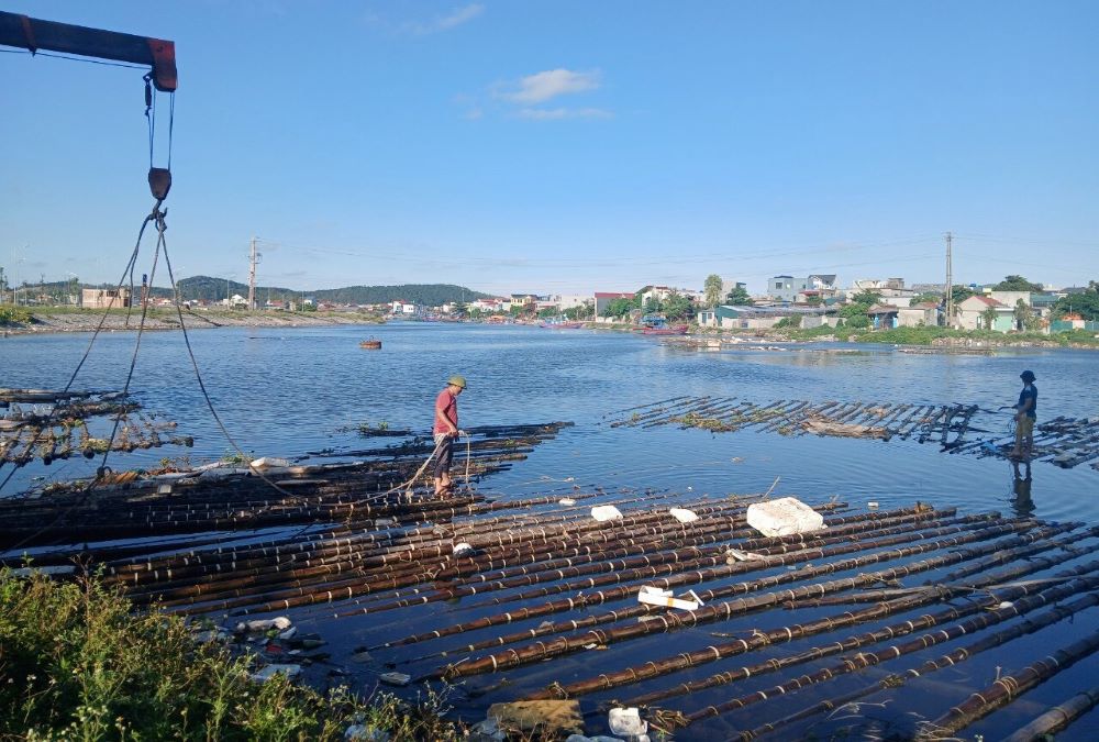 The authorities mobilized manpower and machinery to pull rafts that had illegally encroached on the river to shore. Photo: Le Thang