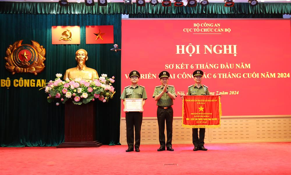 Bộ trưởng Lương Tam Quang trao Cờ thi đua của Thủ tướng Chính phủ tặng Phòng Tổ chức biên chế và chỉ tiêu đào tạo; trao Danh hiệu Chiến sĩ thi đua toàn lực lượng CAND tặng 1 cá nhân thuộc Cục Tổ chức cán bộ. Ảnh: Bộ Công an