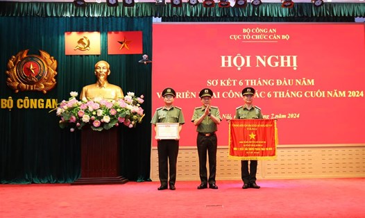 Bộ trưởng Lương Tam Quang trao Cờ thi đua của Thủ tướng Chính phủ tặng Phòng Tổ chức biên chế và chỉ tiêu đào tạo; trao Danh hiệu Chiến sĩ thi đua toàn lực lượng CAND tặng 1 cá nhân thuộc Cục Tổ chức cán bộ. Ảnh: Bộ Công an