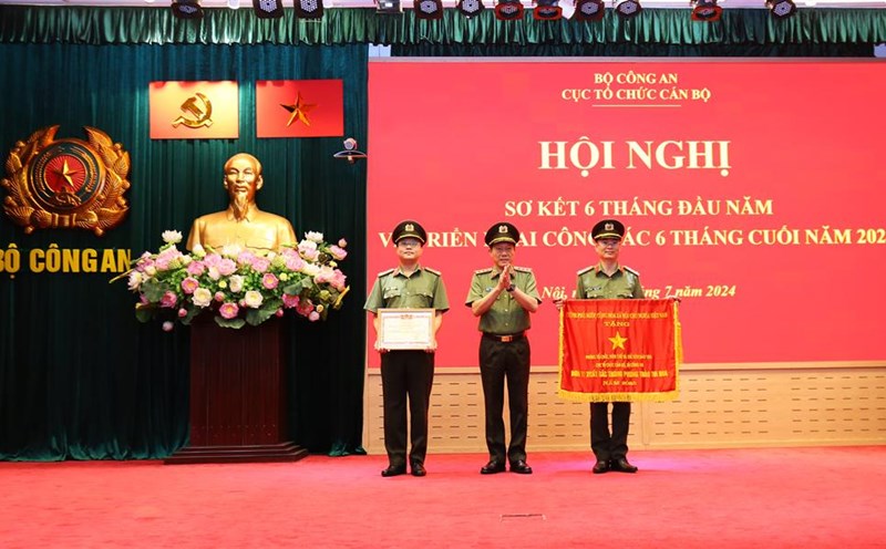Bộ trưởng Lương Tam Quang trao Cờ thi đua của Thủ tướng Chính phủ tặng Phòng Tổ chức biên chế và chỉ tiêu đào tạo; trao Danh hiệu Chiến sĩ thi đua toàn lực lượng CAND tặng 1 cá nhân thuộc Cục Tổ chức cán bộ. Ảnh: Bộ Công an