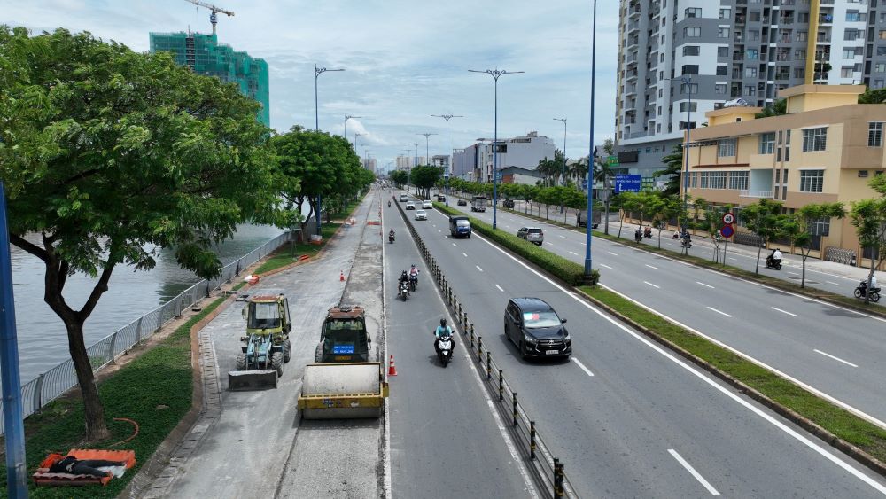 Hiện công nhân cùng các thiết bị, máy móc đang thi công mở rộng làn xe máy đường Võ Văn Kiệt (bên phải tuyến hướng từ nút giao Tân Kiên về đường hầm Thủ Thiêm). Ảnh: Anh Tú