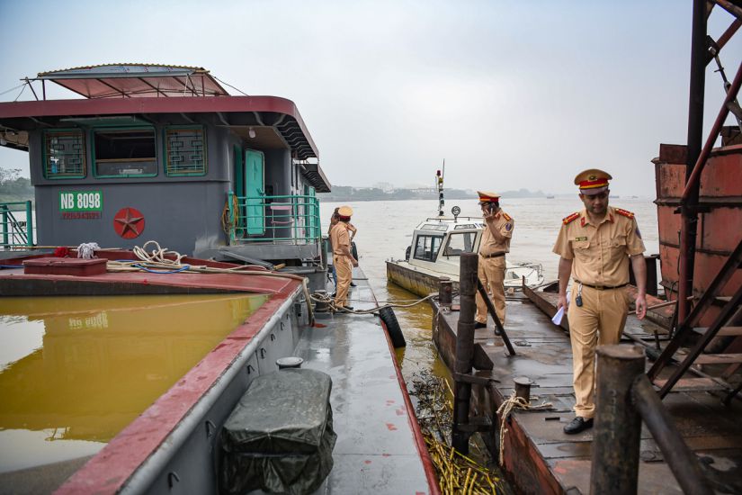 Forces intersectorielles inspectant et traitant les navires exploitant illegalement du sable. Photo : Departement de la police de la circulation - Ministere de la Securite publique