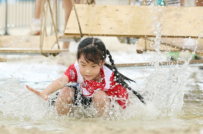 The little runner is not afraid to get dirty and overcomes the challenge of swinging through the water. Photo: OMO  