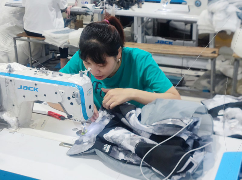 Thường xuyên ngồi cúi làm việc, chị Mai - nữ công nhân may mặc được chẩn đoán cong vẹo cột sống. Ảnh: Mạnh Cường.
