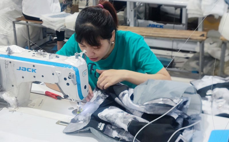 Thường xuyên ngồi cúi làm việc, chị Mai - nữ công nhân may mặc được chẩn đoán cong vẹo cột sống. Ảnh: Mạnh Cường.