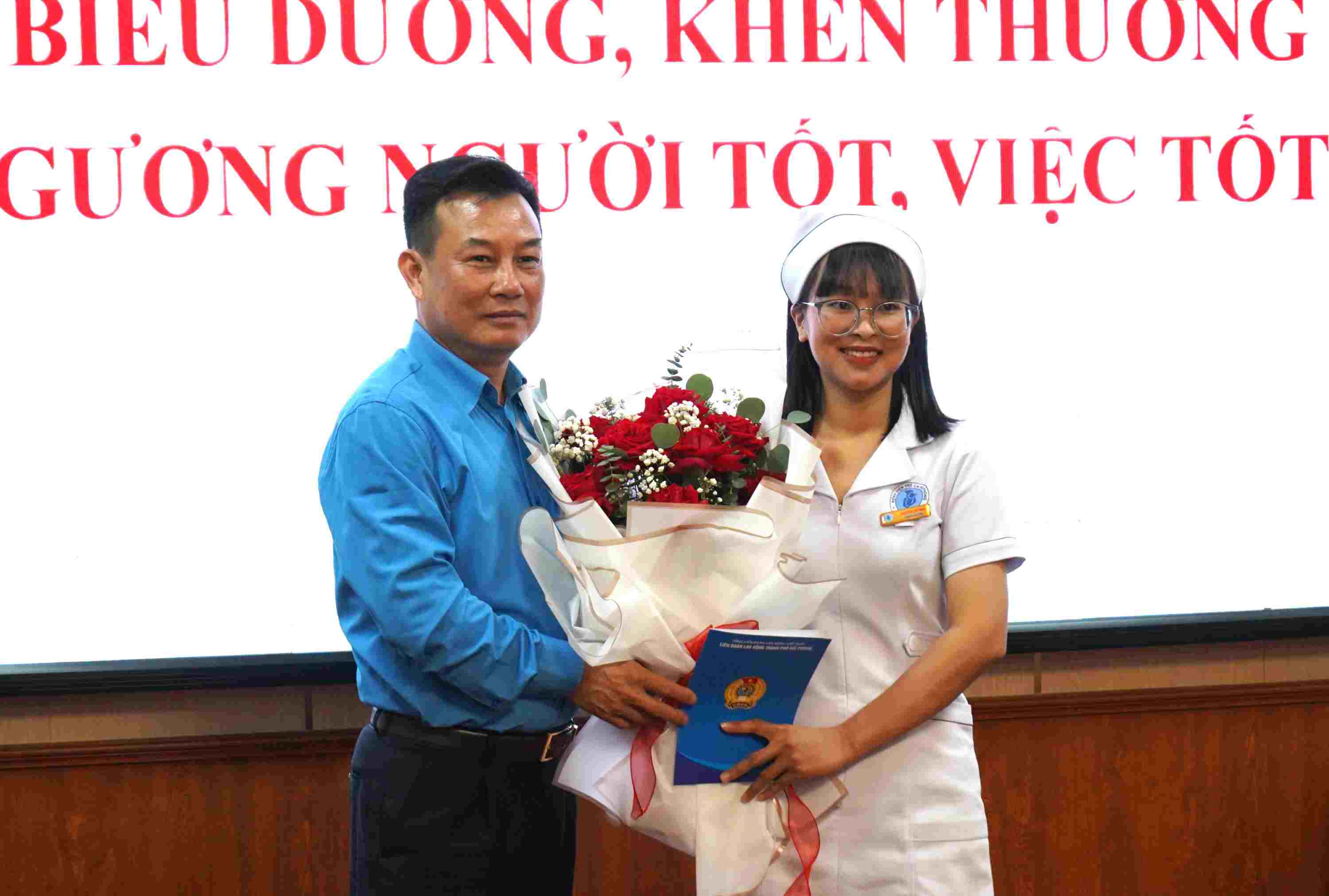 Phó Chủ tịch LĐLĐ TP.Hải Phòng Nguyễn Văn Phiệt khen thưởng điều dưỡng cứu sống cháu bé 7 ngày tuổi bị sặc sữa trên đường. Ảnh: Mai Dung