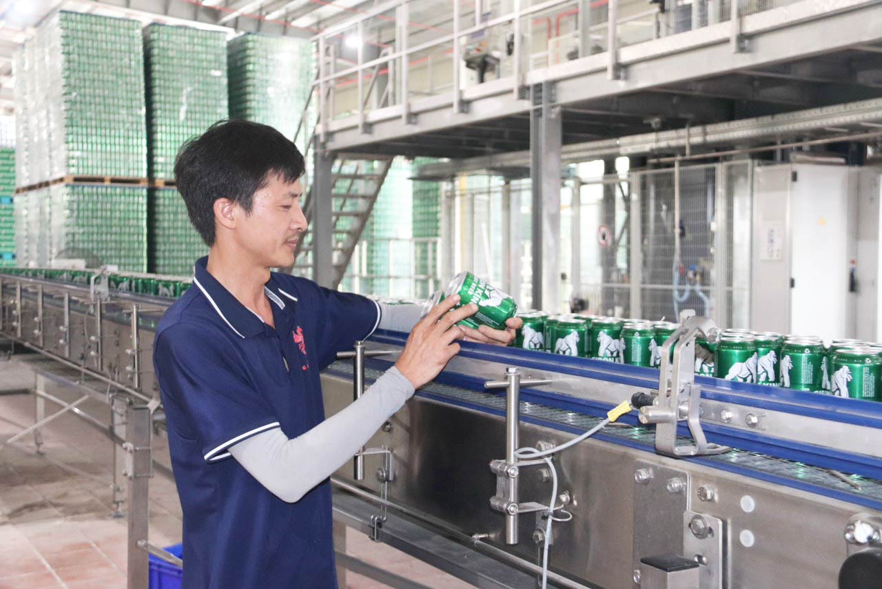 Les techniciens de l'usine de biere Sao Vang - Societe par actions du groupe Hoanh Son inspectent les produits avant de sortir de l'usine. Photo : Quang Dai