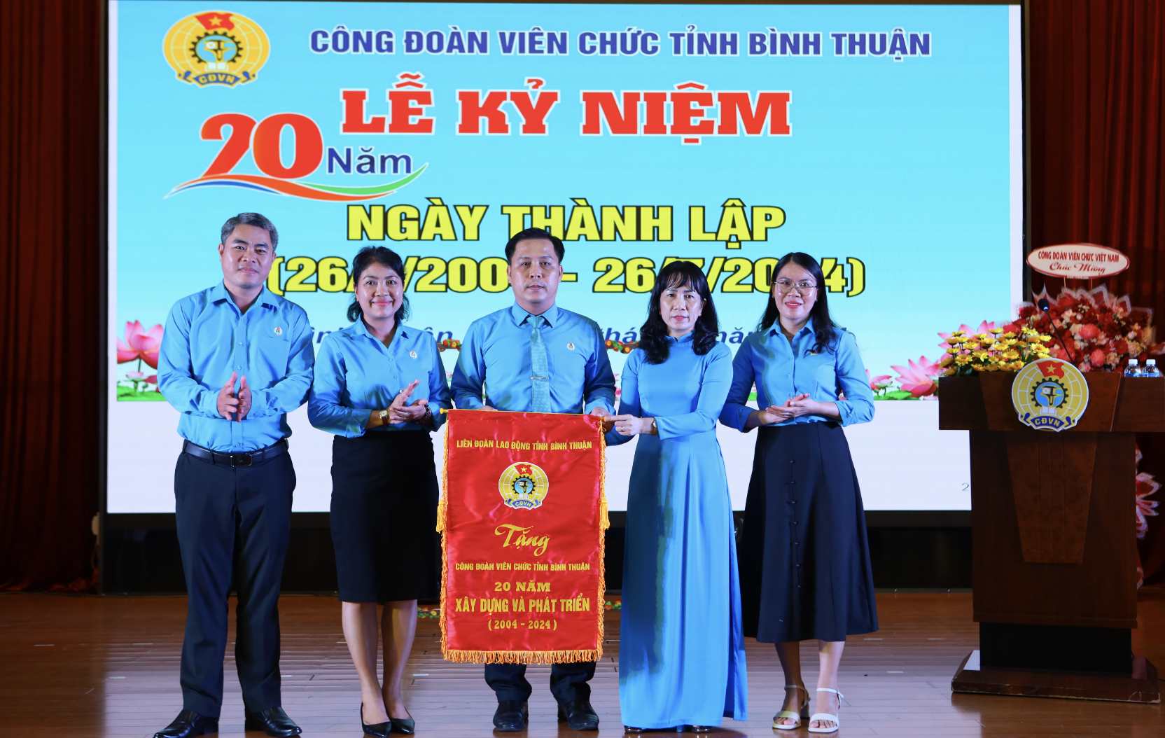 Bà Đặng Thị Thanh Hoa - Phó chủ tịch thường trực LĐLĐ tỉnh Bình Thuận trao tặng CĐVC tỉnh Bình Thuận bức trướng đánh giấu cột mốc 20 năm. Ảnh: Duy Tuấn 