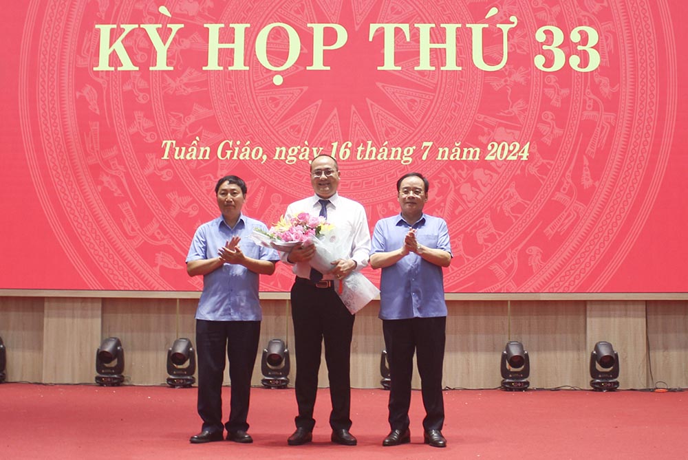 Ông Mùa A Sơn - Phó Bí thư Tỉnh ủy Điện Biên (phải) và ông Phạm Khắc Quân - Trưởng ban Tổ chức Tỉnh ủy (trái) tặng hoa chúc mừng ông Lê Xuân Cảnh - tân Bí thư Huyện ủy Tuần Giáo. Ảnh: Đức Linh