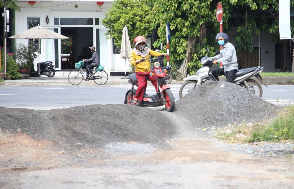 Người dân phải vượt chướng ngại vật để đi lại vì đoạn đường chưa được phép đấu nối với Quốc lộ 1. Ảnh: Hưng Thơ.