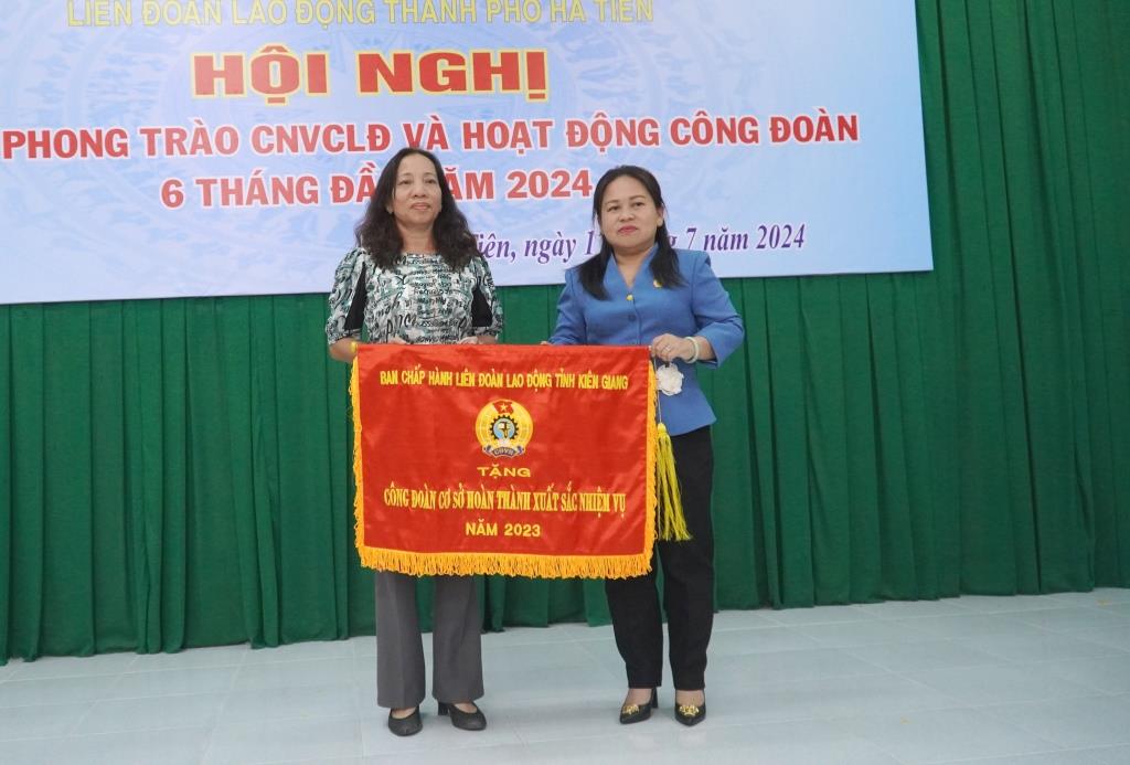 Kien Giang성 노동총연맹 위원장 Truong Thanh Thuy가 우수한 성과를 거둔 노동조합에 경쟁 깃발을 수여하고 있습니다. 사진: Van Si