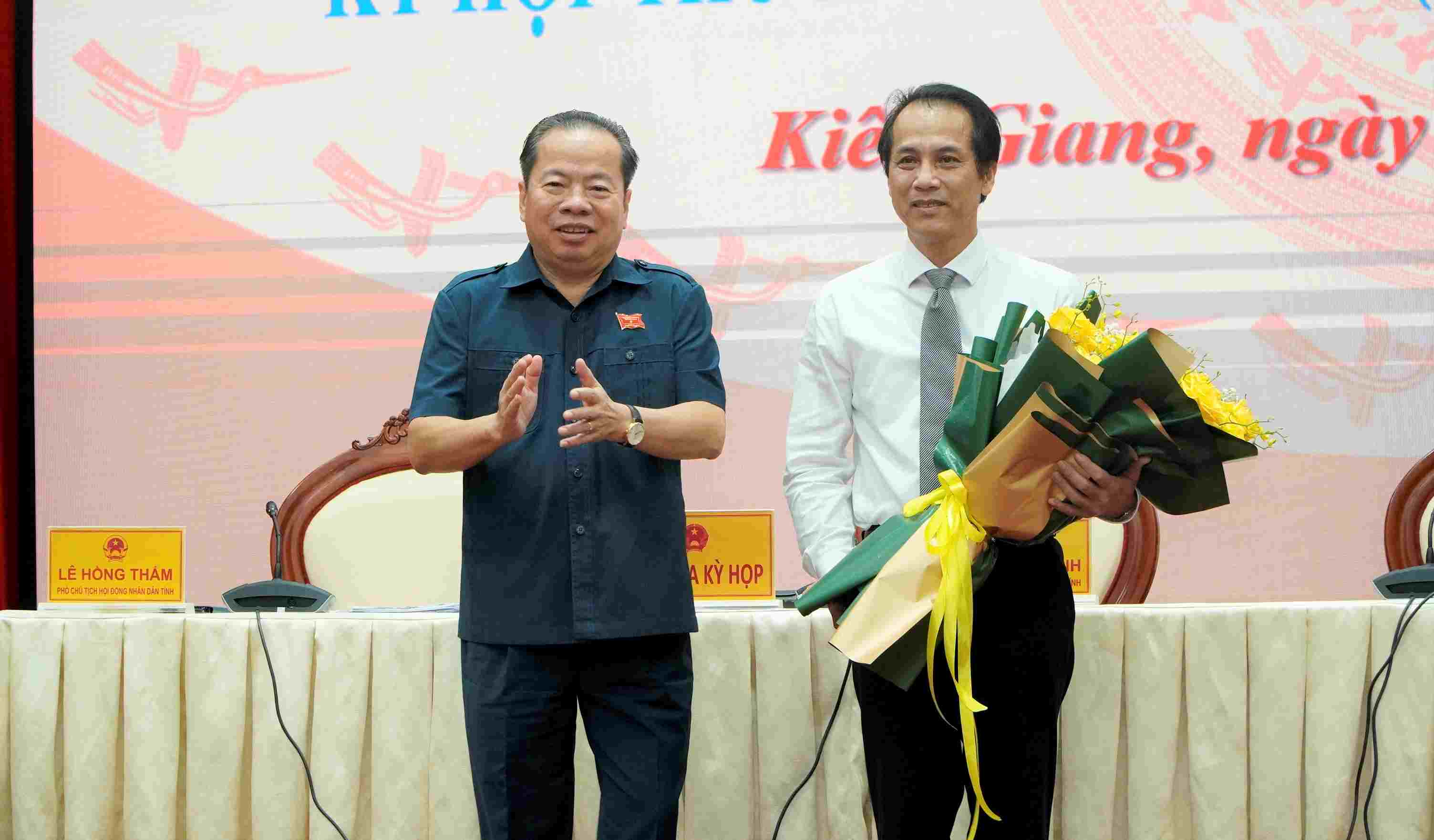 Chủ tịch HĐND tỉnh Kiên Giang Mai Văn Huỳnh tặng hoa chúc mừng ông Hồ Văn Dũng (phải ảnh). Ảnh: Nguyên Anh