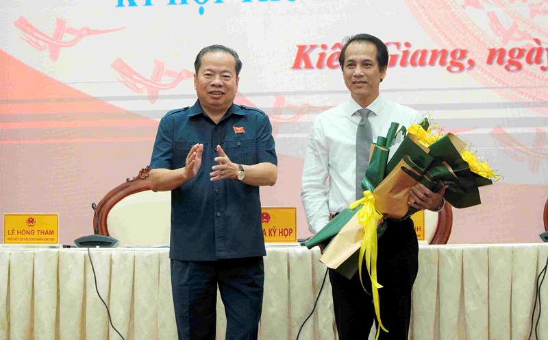 Chủ tịch HĐND tỉnh Kiên Giang Mai Văn Huỳnh tặng hoa chúc mừng ông Hồ Văn Dũng (phải ảnh). Ảnh: Nguyên Anh