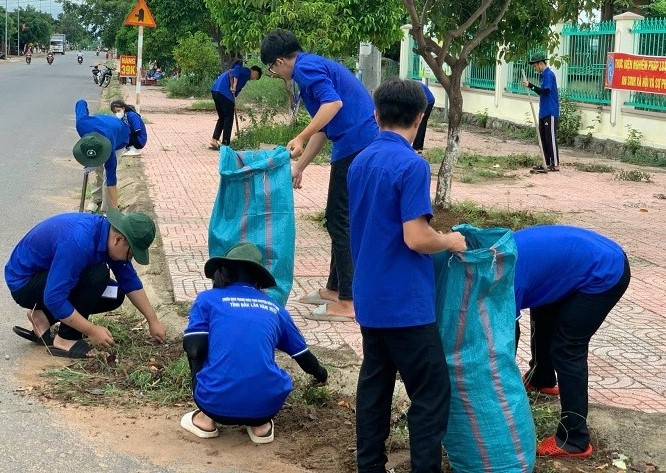 A group of students sweeps a street in Buon Ma Thuot City. Photo: Bao Trung