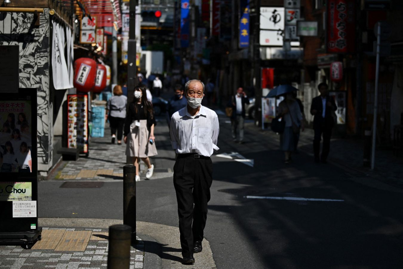 Một người đàn ông cao tuổi đi bộ trên đường phố ở khu Shinbashi, Tokyo, Nhật Bản. Ảnh: AFP