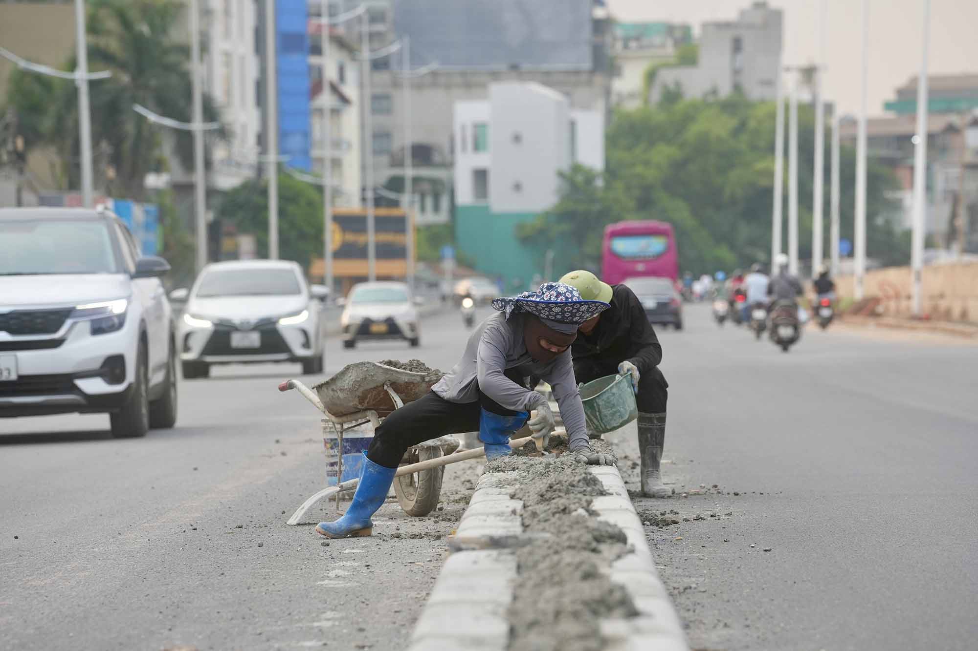  Công nhân đang thi công hoàn thiện hạng mục dải phân cách. Ảnh: Hữu Chánh