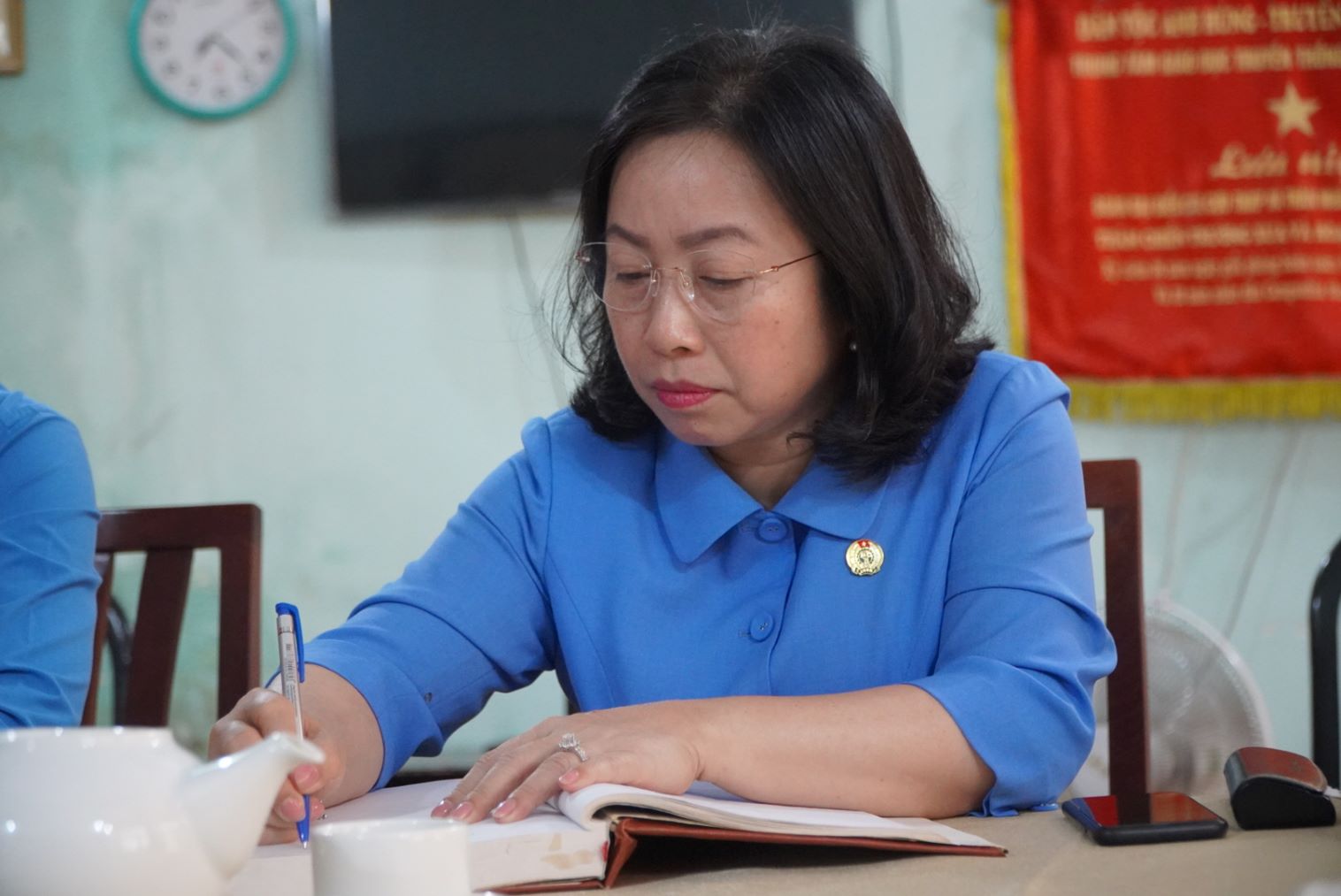 Standing Vice President of the Vietnam General Confederation of Labor Thai Thu Xuong writes his thoughts in the souvenir book at Hill 82 Martyrs Cemetery. Photo: Chan Phuc