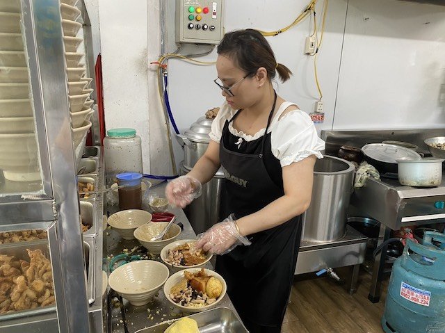 Chị Hoa - chủ quán xôi da gà sốt chua cay đang làm xôi cho khách. Ảnh: Minh Thương