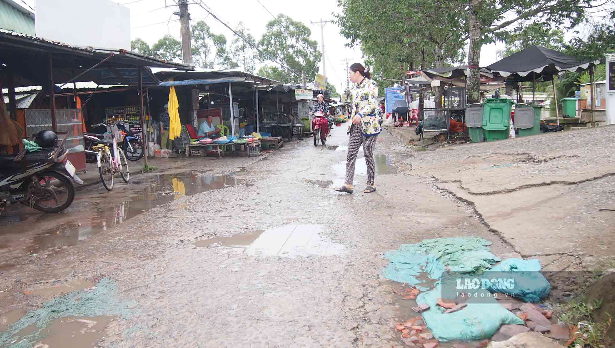 Người dân dùng bao đất, gạch để vá tạm thời những ổ gà, ổ voi.