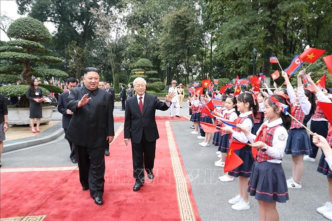 Ngày 1.3.2019, Tổng Bí thư, Chủ tịch nước Nguyễn Phú Trọng và Chủ tịch Triều Tiên Kim Jong-un vẫy tay chào thiếu nhi Hà Nội đón đoàn. Ảnh: Trí Dũng/TTXVN 