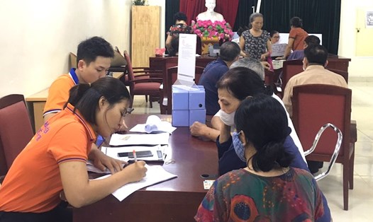 BHXH huyện Thanh Trì phối hợp vận động người nhận lương hưu và trợ cấp BHXH qua phương thức không dùng tiền mặt. Ảnh: BHXH Hà Nội