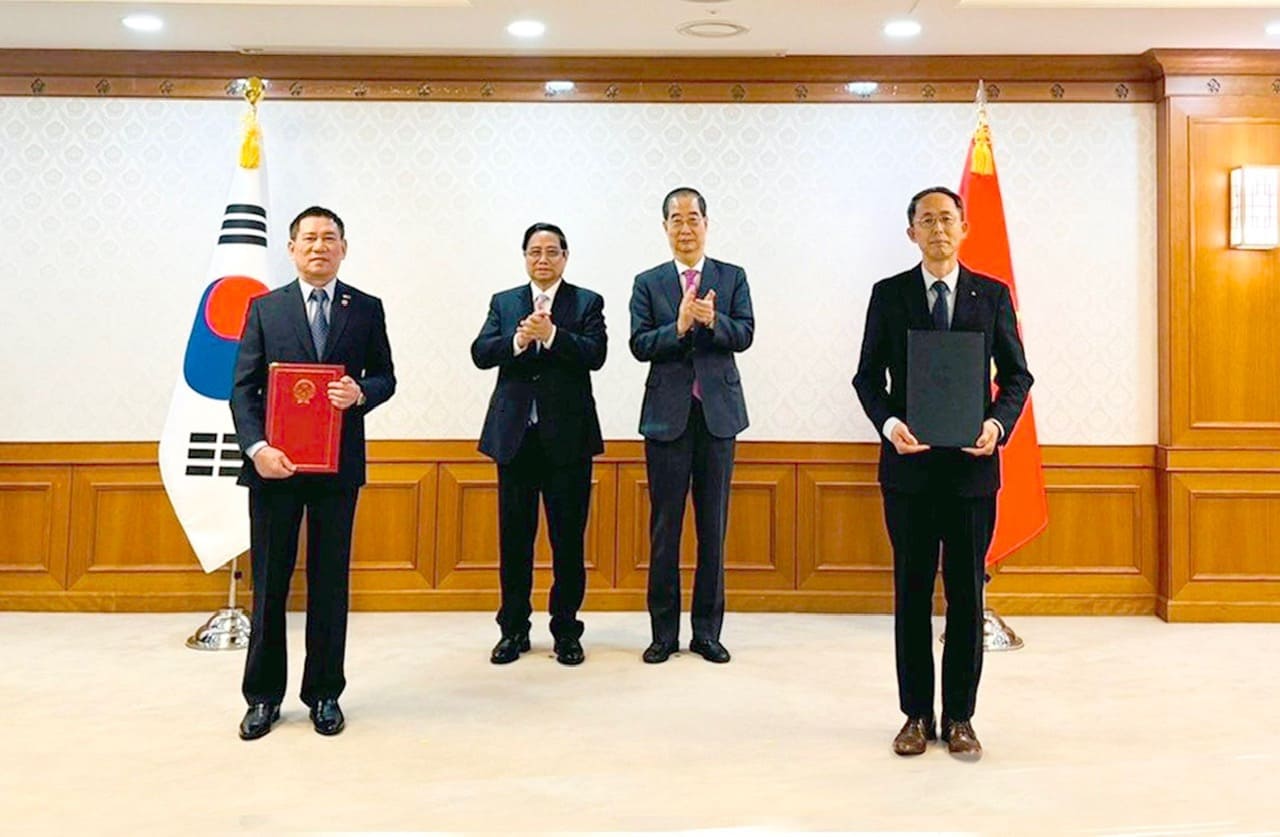 Bộ trưởng Bộ Tài chính Hồ Đức Phớc và Giám đốc điều hành cấp cao của Ngân hàng Xuất nhập khẩu Hàn Quốc - ông Hwang Ki-yeon trao đổi văn kiện. Ảnh: Ngọc Trâm. 