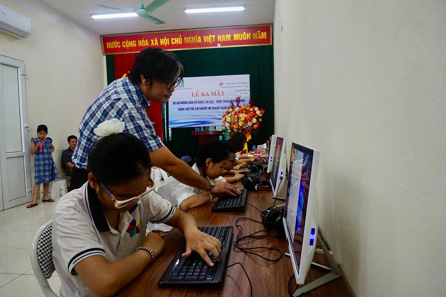 Giảng viên Nguyễn Trung Thái hướng dẫn các em nhỏ làm quen với thiết bị công nghệ. Ảnh: Nhật Minh