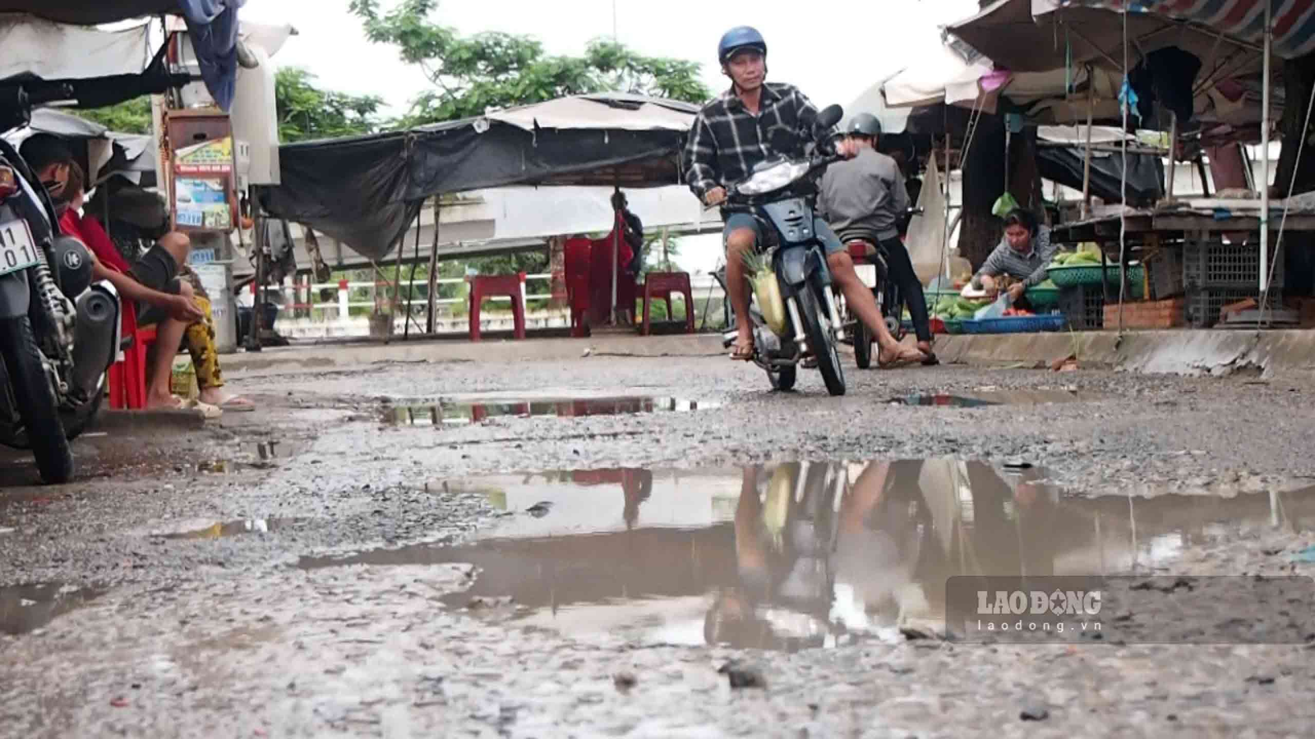 Nền đường bong tróc, nhiều ổ gà, ổ voi là nơi đọng nước mỗi khi trời mưa. Ảnh: Nhóm PV