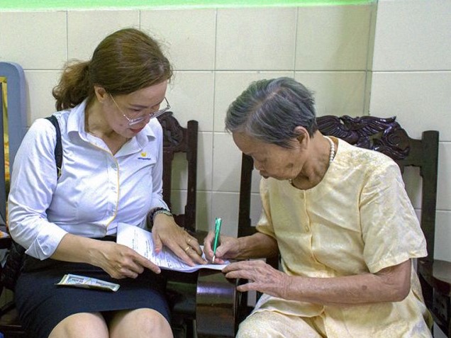 Nhân viên Bưu điện tỉnh Cà Mau phát lương hưu cho cán bộ hưu trí tại nhà.Ảnh: Nhật Hồ