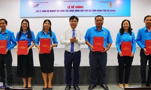 Tiến sĩ Vũ Anh Đức - Chủ tịch Hội đồng Trường ĐH Tôn Đức Thắng (giữa) trao chứng nhận tốt nghiệp cho cán bộ công đoàn. Ảnh: Đức Long