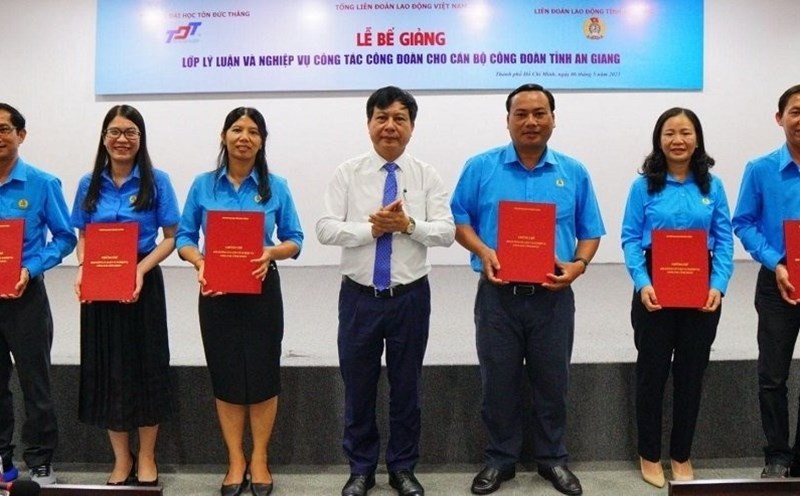 Tiến sĩ Vũ Anh Đức - Chủ tịch Hội đồng Trường ĐH Tôn Đức Thắng (giữa) trao chứng nhận tốt nghiệp cho cán bộ công đoàn. Ảnh: Đức Long