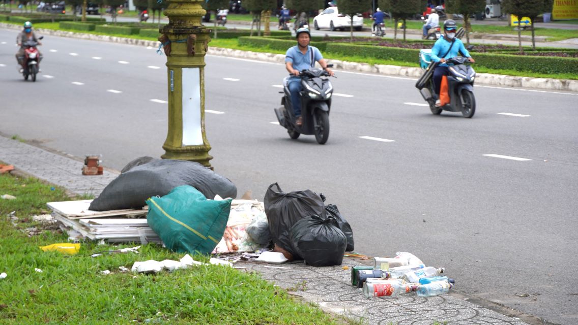 Dưới chân các trụ tại vỉa hè, những túi nilon chứa rác thải được chất đống. 