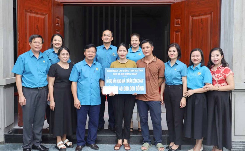 Ông Nguyễn Văn Danh - Chủ tịch LĐLĐ tỉnh Hà Tĩnh trao tiền hỗ trợ làm nhà "Mái ấm công đoàn". Ảnh: Xuân Truyền.