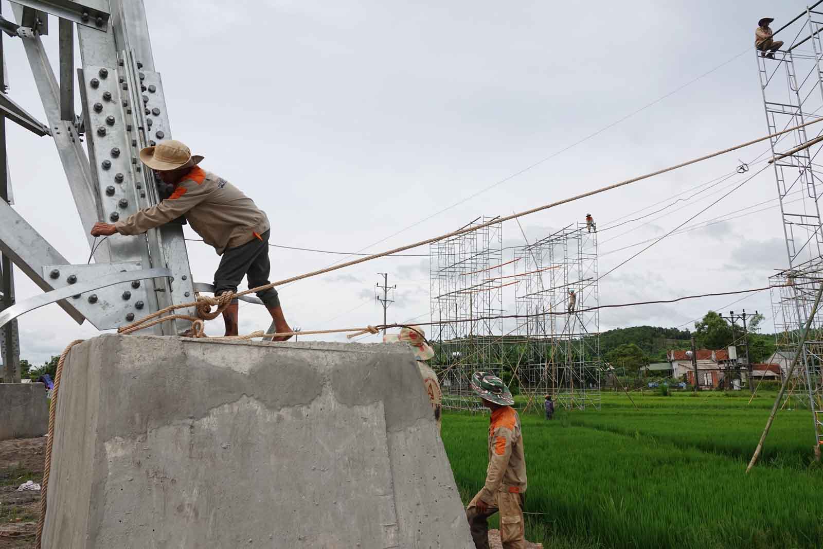 Tying the scaffolding rope to the electric pole helps the scaffold to be sturdy and safe when pulling the rope up the pole. Photo: Tran Tuan.